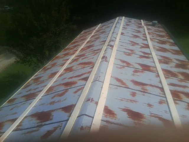 Rusted metal roof panels with new wood purlins before replacement — Storm Damage Roof Repair in Mount Morris by Roofing Brothers